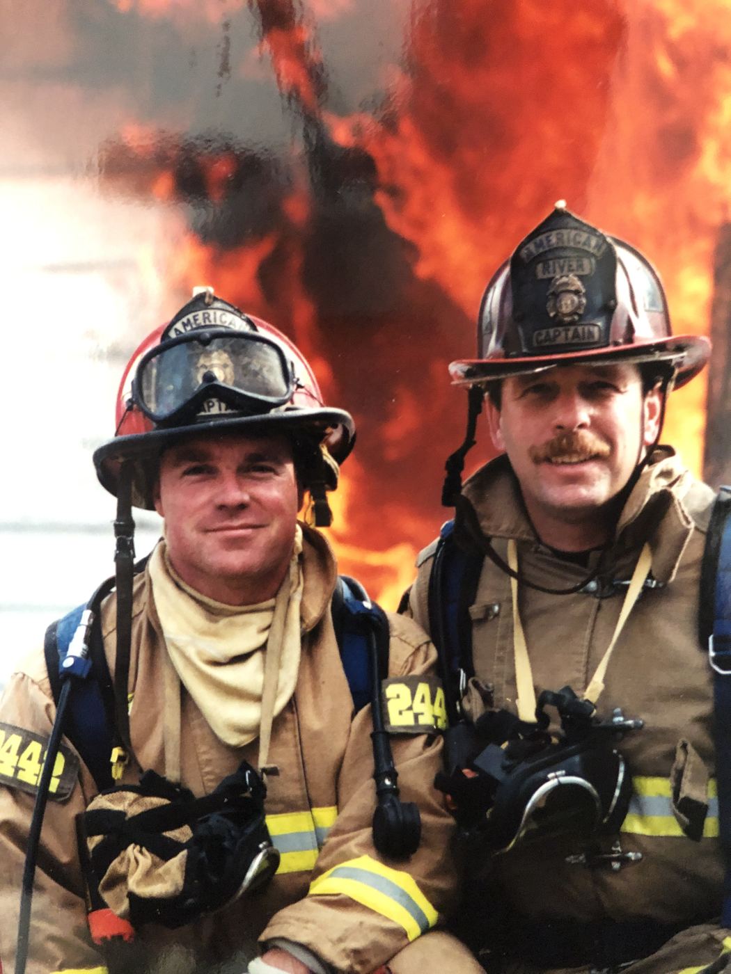 Two Sacramento Metro firefighters in front of flames